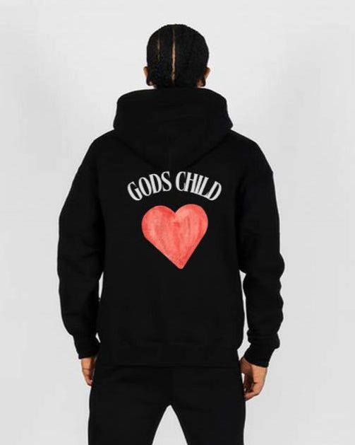 Person wearing a black hoodie with 'Godd's Child' text and heart design on the back, standing against a white background.