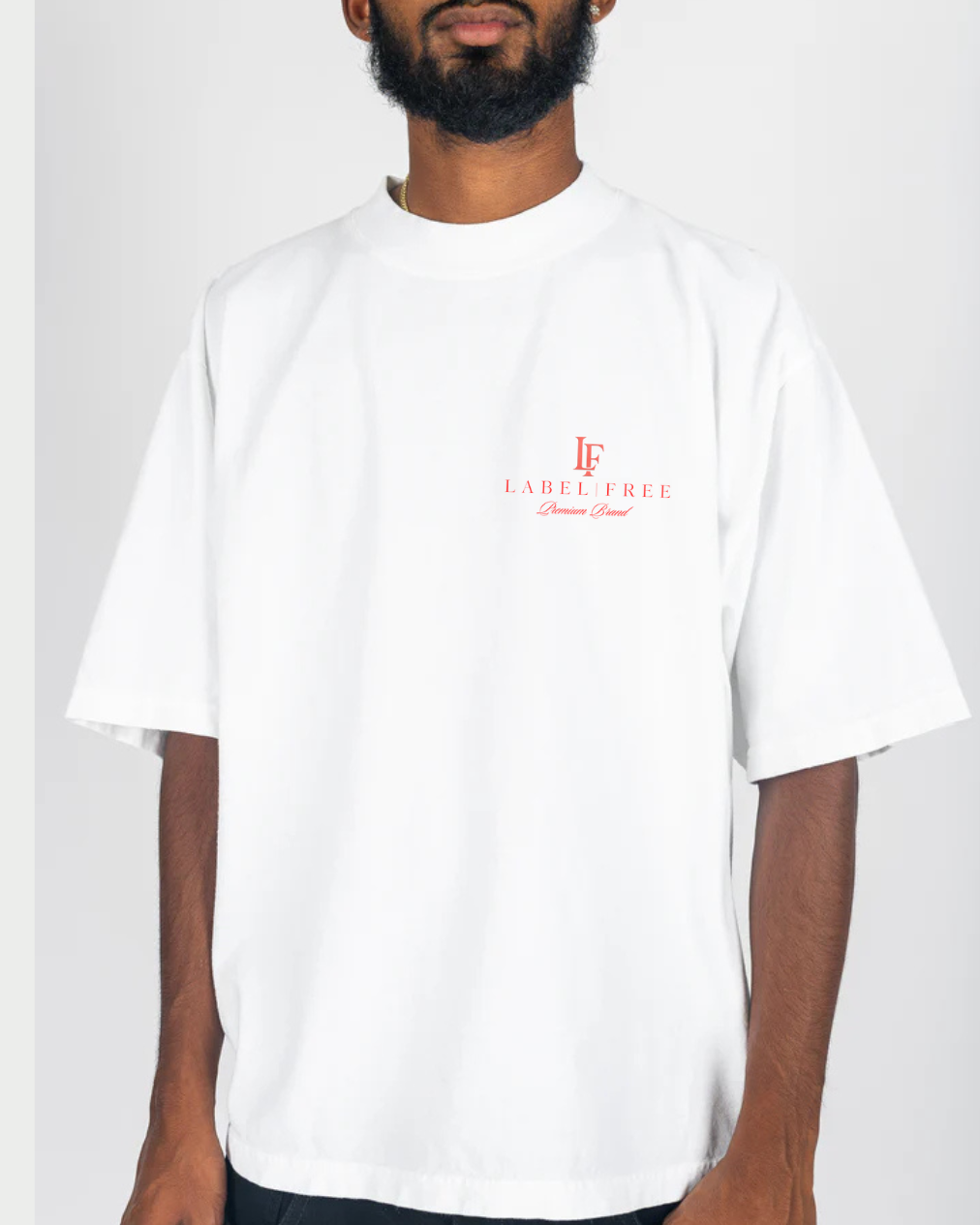 Person wearing a white t-shirt with a red logo on a plain background